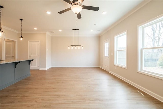 unfurnished living room with ornamental molding, a healthy amount of sunlight, and light wood-type flooring