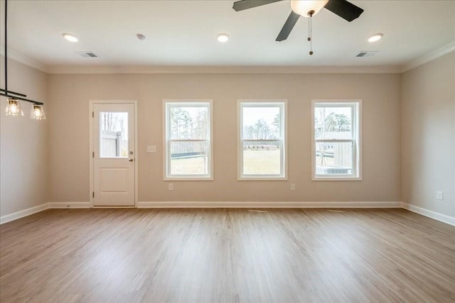 spare room with baseboards, visible vents, and ornamental molding