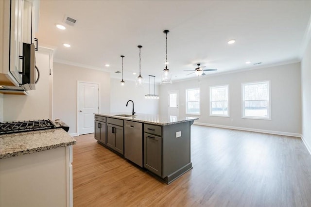 kitchen with ceiling fan, light wood-type flooring, a sink, ornamental molding, and stainless steel appliances