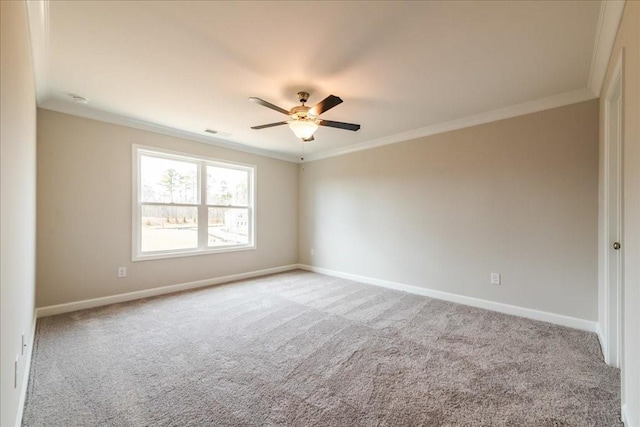 spare room with crown molding, a ceiling fan, baseboards, and light carpet