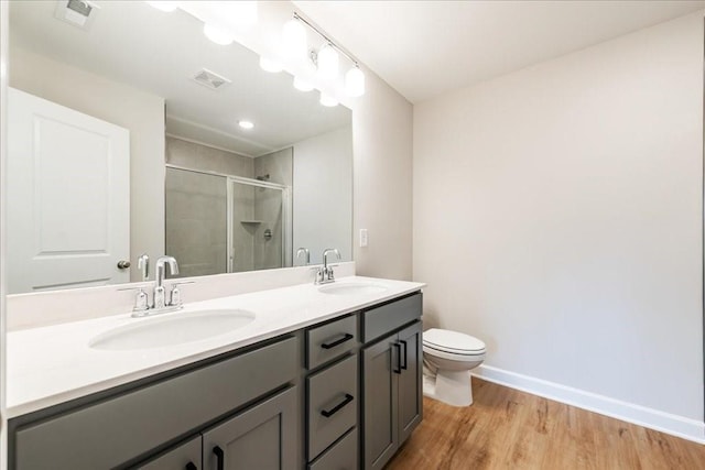 bathroom featuring a sink, a stall shower, double vanity, and visible vents