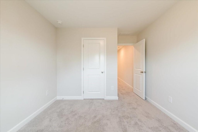 unfurnished bedroom featuring carpet floors and baseboards