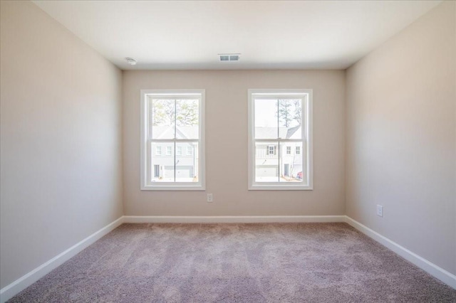 carpeted spare room with baseboards and visible vents
