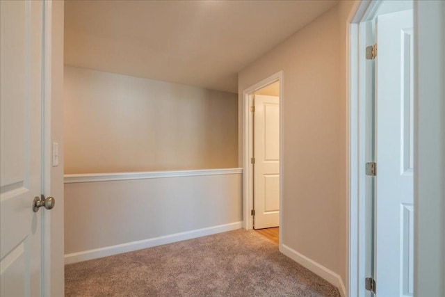 corridor featuring carpet floors and baseboards