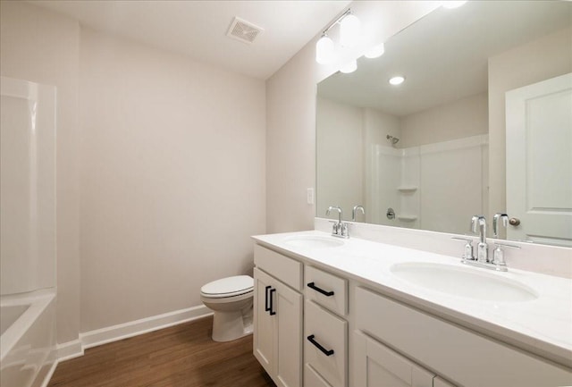 full bathroom with a sink, baseboards, toilet, and wood finished floors