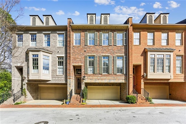 view of property featuring a garage and brick siding