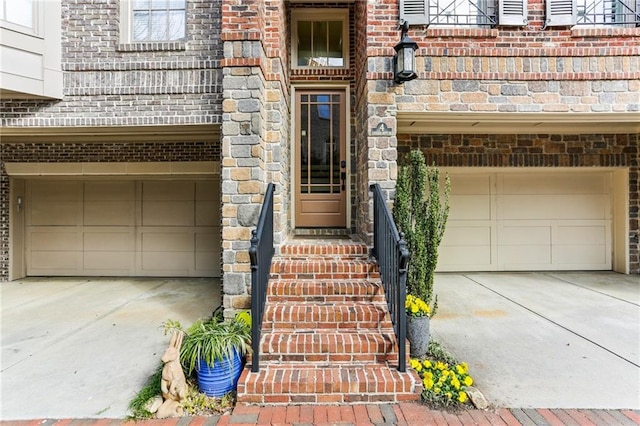 entrance to property featuring concrete driveway and an attached garage