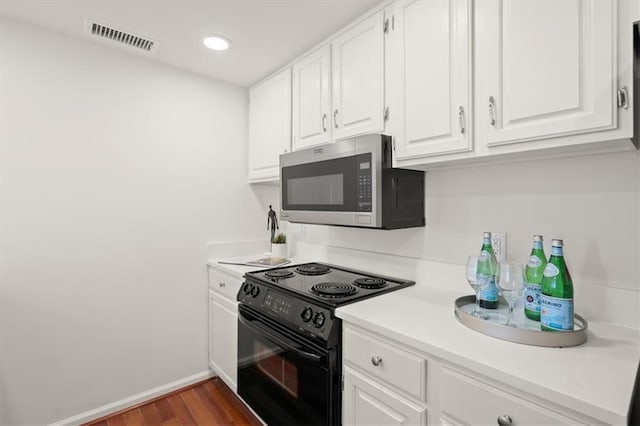 kitchen with dark hardwood / wood-style flooring, white cabinetry, and black range with electric stovetop