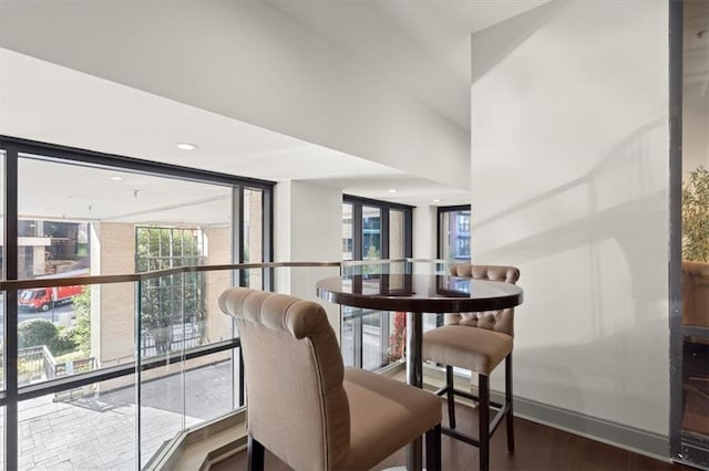 dining room with wood-type flooring and a wall of windows