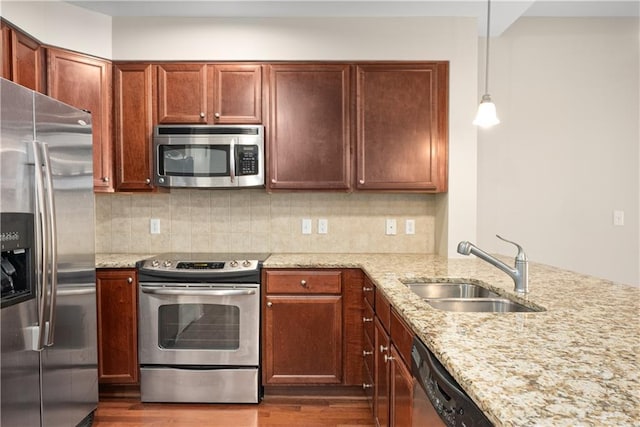 kitchen featuring hanging light fixtures, sink, tasteful backsplash, and stainless steel appliances