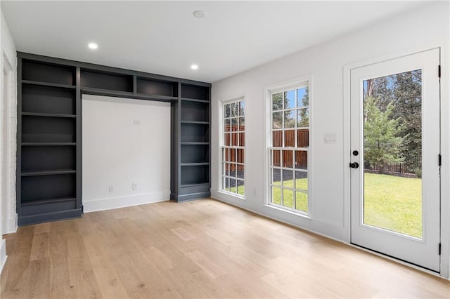 interior space with built in features, plenty of natural light, and light hardwood / wood-style flooring