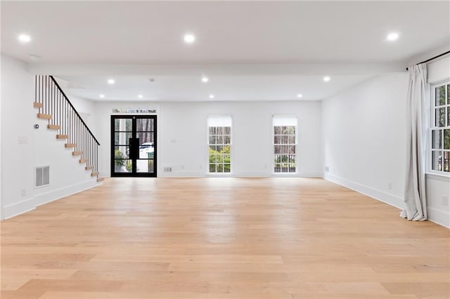 unfurnished living room with light hardwood / wood-style flooring and french doors