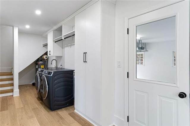 washroom with separate washer and dryer and light hardwood / wood-style flooring