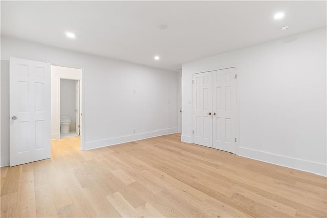 interior space featuring ensuite bathroom, a closet, and light wood-type flooring