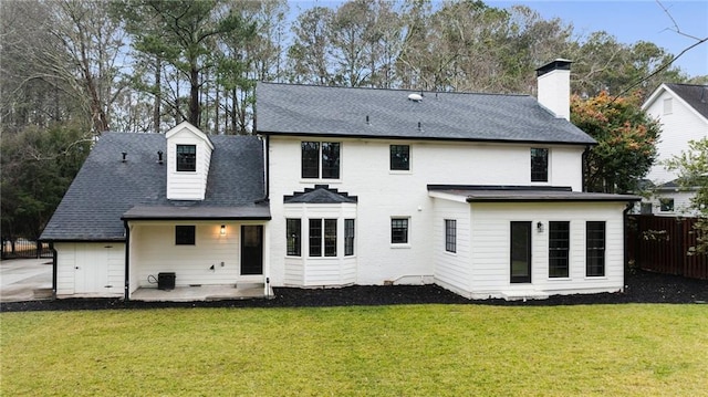 rear view of house featuring a patio area and a lawn