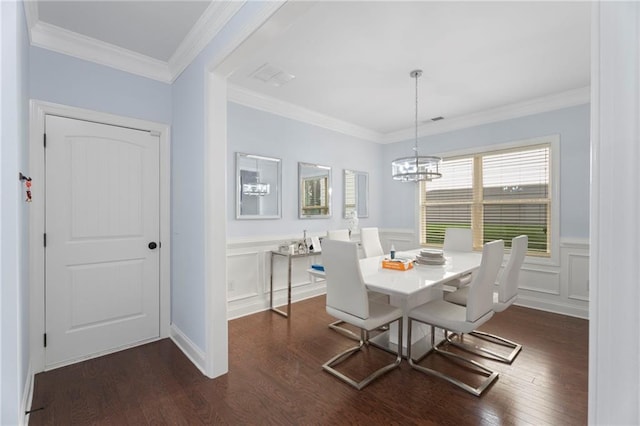 2040 Harvest Ridge Cir, Buford, GA 30519 - dining space featuring dark wood-style flooring, a chandelier, wainscoting, a decorative wall, and ornamental molding
