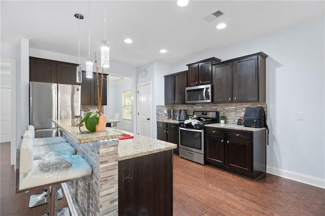 2040 Harvest Ridge Cir, Buford, GA 30519 - kitchen featuring appliances with stainless steel finishes, dark brown cabinetry, decorative backsplash, light stone countertops, and recessed lighting