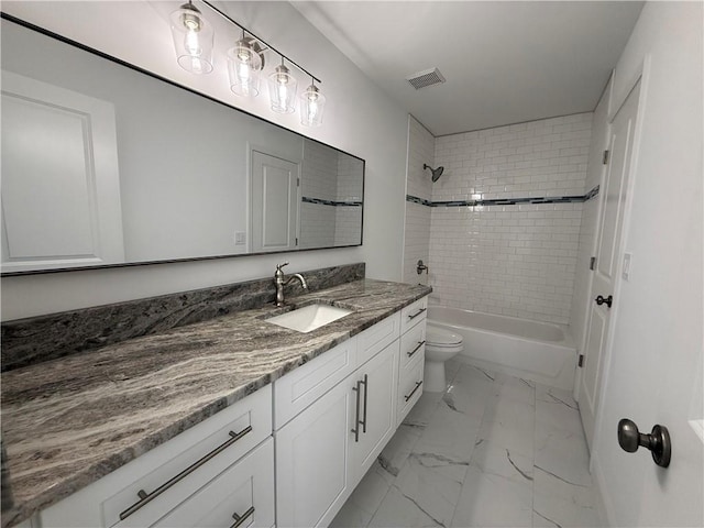 full bathroom featuring toilet, vanity, and tiled shower / bath combo