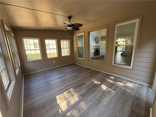 unfurnished sunroom featuring ceiling fan