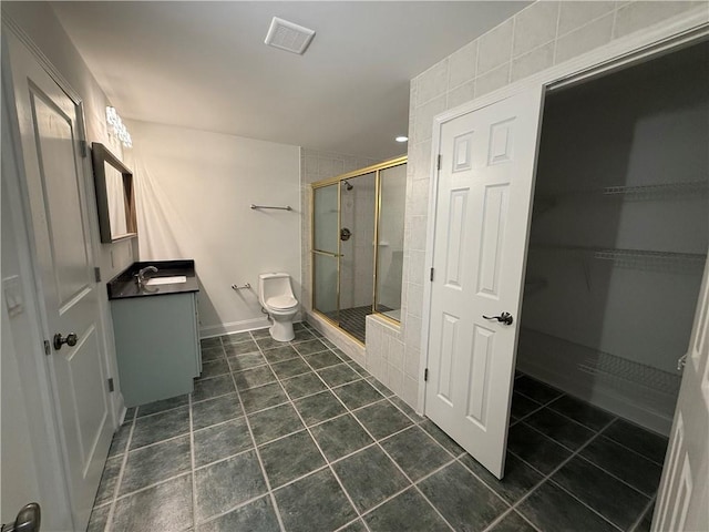 bathroom featuring tile patterned floors, vanity, toilet, and a shower with door