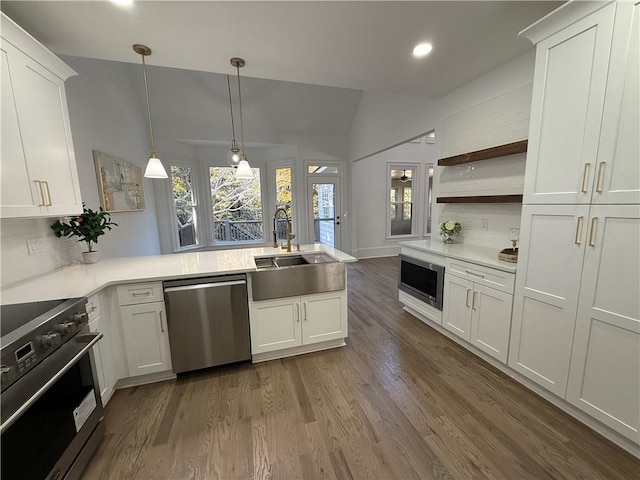 kitchen with backsplash, white cabinetry, stainless steel appliances, and decorative light fixtures