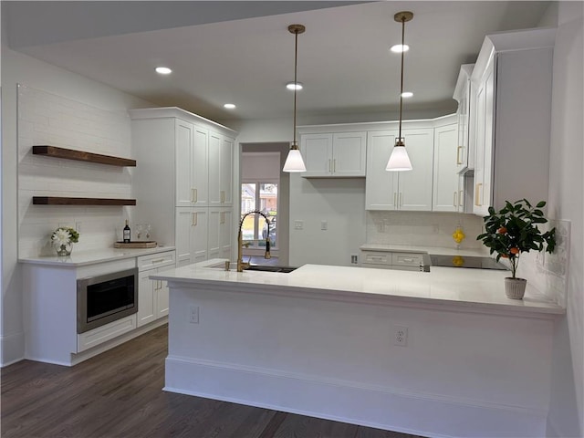 kitchen featuring white cabinets, pendant lighting, dark wood-type flooring, and sink