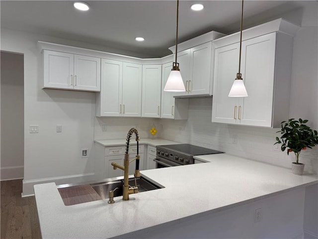 kitchen featuring kitchen peninsula, high end stove, decorative light fixtures, and white cabinetry