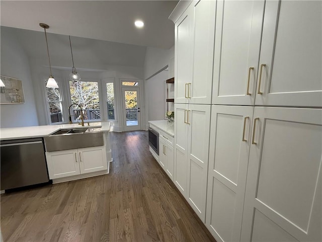 kitchen with appliances with stainless steel finishes, dark wood-type flooring, sink, white cabinetry, and hanging light fixtures