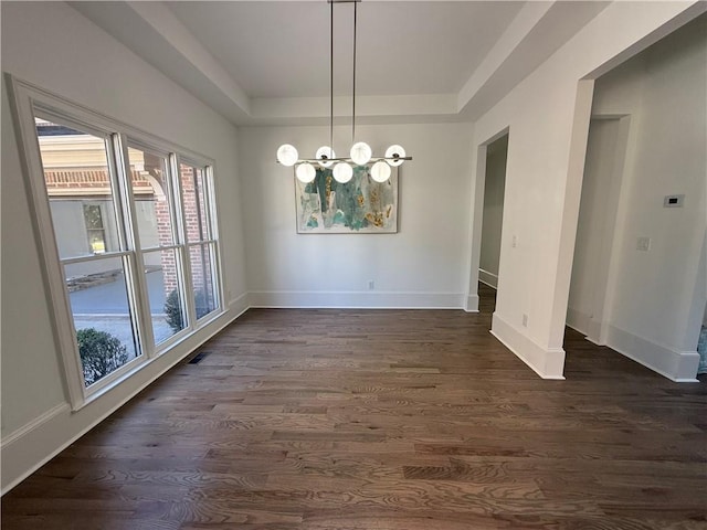 unfurnished dining area featuring dark hardwood / wood-style flooring and an inviting chandelier