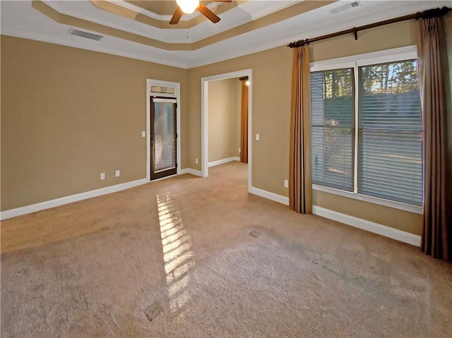 unfurnished room featuring a tray ceiling, light carpet, ceiling fan, and ornamental molding