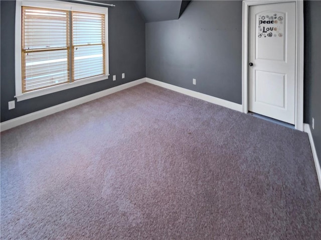 bonus room with dark colored carpet and lofted ceiling