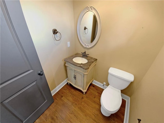 bathroom featuring wood-type flooring, vanity, and toilet