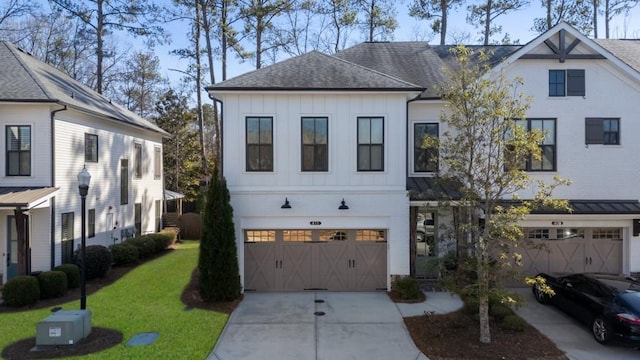 modern inspired farmhouse featuring a garage, driveway, roof with shingles, board and batten siding, and a front yard