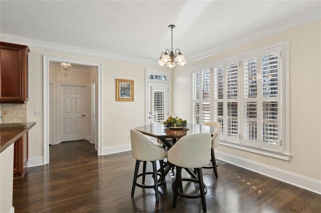 dining area featuring crown molding, dark wood-type flooring, and a notable chandelier