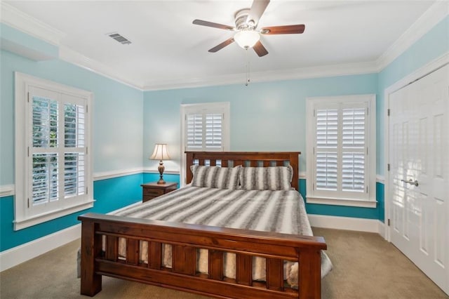 carpeted bedroom with baseboards, visible vents, and crown molding