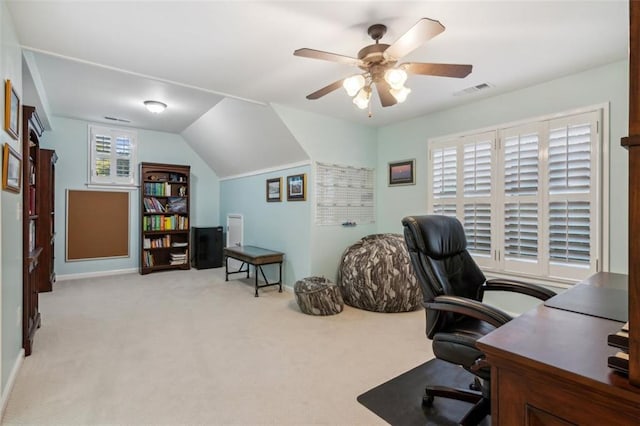 carpeted home office with lofted ceiling, visible vents, and ceiling fan