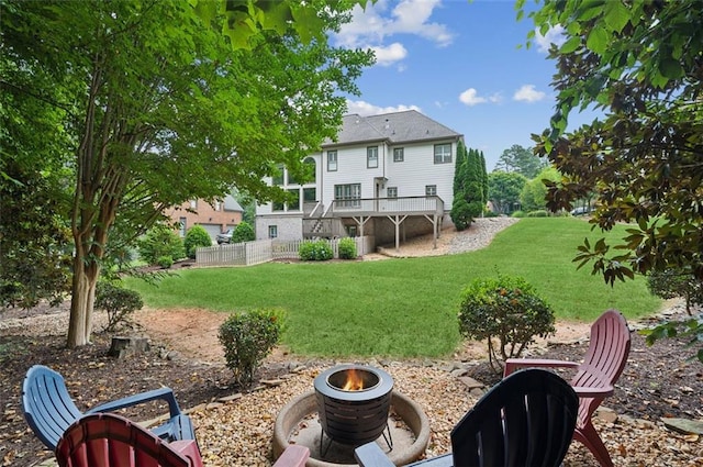 back of house with an outdoor fire pit, a yard, a deck, and stairs