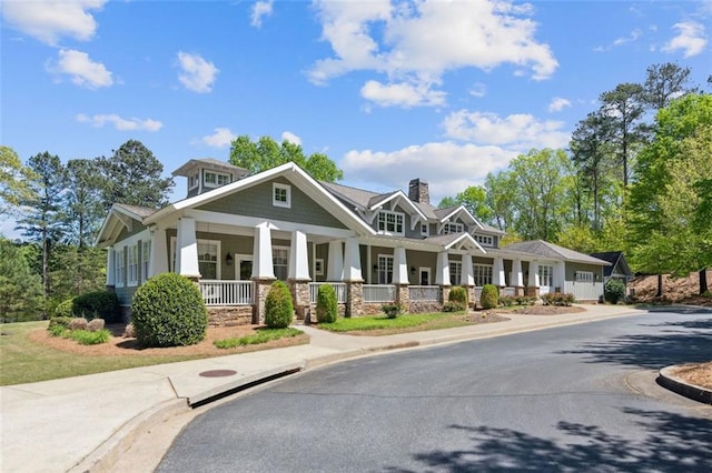 view of front of house with covered porch and a chimney