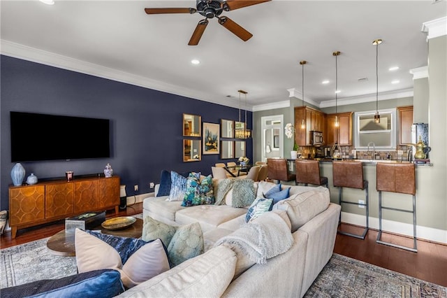 living area featuring ornamental molding, recessed lighting, baseboards, and wood finished floors