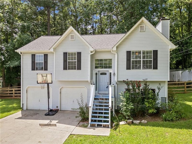 raised ranch with a garage and a front lawn