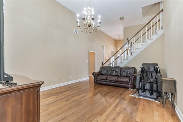 656 Deerwood Way, Evans, GA 30809 - living area with stairs, light wood-type flooring, baseboards, a chandelier, and a high ceiling