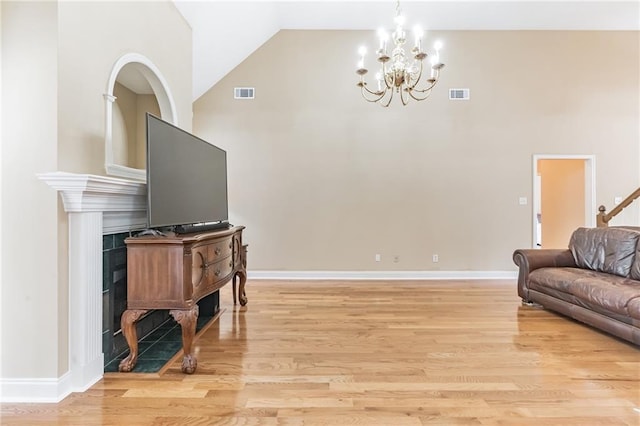 656 Deerwood Way, Evans, GA 30809 - living room featuring light wood-type flooring, a chandelier, a fireplace with flush hearth, high vaulted ceiling, and baseboards