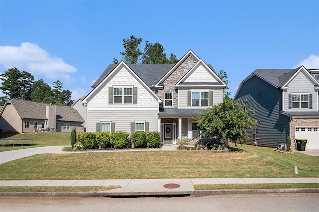 craftsman inspired home featuring a garage and a front lawn