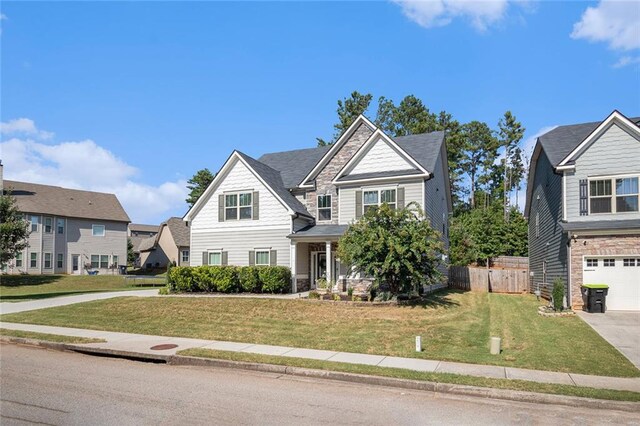 craftsman house featuring a garage and a front lawn