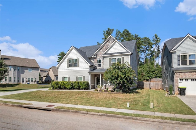 view of front of home featuring an attached garage, fence, concrete driveway, and a front yard