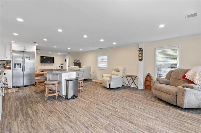 living room featuring crown molding and light hardwood / wood-style floors