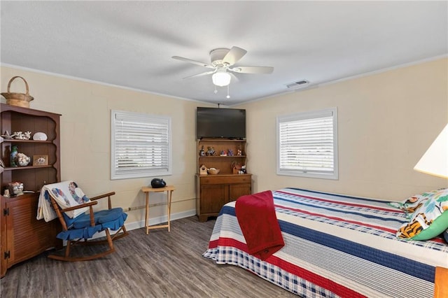 bedroom with dark hardwood / wood-style flooring, ceiling fan, and crown molding