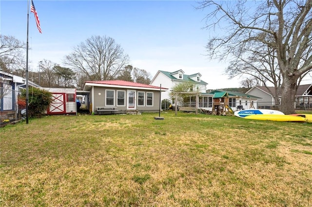 back of house featuring a lawn and a storage unit