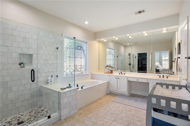 bathroom with visible vents, a healthy amount of sunlight, a stall shower, and a bath