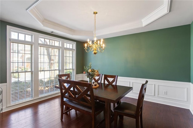 dining space with visible vents, a tray ceiling, dark wood-style floors, wainscoting, and a chandelier